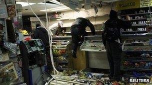 Looters rampage through a convenience store in Hackney, east London