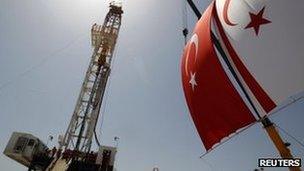 Turkish and Turkish Cypriot flags wave next to a drilling tower at Trikomo northern Cyprus