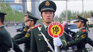 Chinese embassy guards march towards the US embassy compound in Beijing on April 27, 2012, amid unconfirmed reports that blind lawyer Chen Guangcheng was currently at the US embassy.