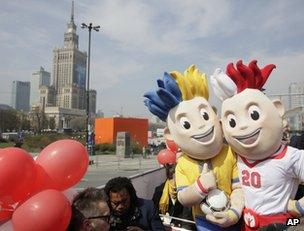 Euro 2012 mascots Slavek, right, and Slavko pose in front of the Palace of Culture in Warsaw, Poland, 20 April