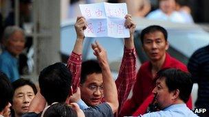 A protester with a banner supporting blind rights activist Chen