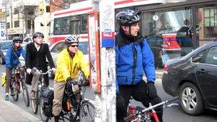 Cyclists wait in traffic