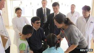 Chen Guangcheng (C) speaks with wife Yuan Weijing (2nd R) and children as US Ambassador Gary Locke (3rd R) and US Assistant Secretary of State for East Asian and Pacific Affairs Kurt Campbell (4th R) stands nearby in a Beijing hospital on 2 May 2012