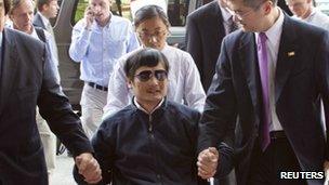 A handout photo from US Embassy Beijing Press office shows blind activist Chen Guangcheng (2nd L) sitting in a wheelchair as he is accompanied by U.S. Ambassador to China Gary Locke (2nd R) at a hospital in Beijing, May 2, 2012.