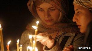 Women light candles during an Orthodox Easter service at the Sioni cathedral in Tbilisi