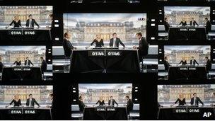 A wall screen shows the televised debate between Socialist Party candidate for the presidential election Francois Hollande and current President and conservative rival for re-election, Nicolas Sarkozy