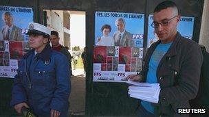 A supporter of the Socialist Forces Front (FFS) party (R) hands out leaflets before their parliamentary election campaign rally in Tizi Ouzou, Algeria