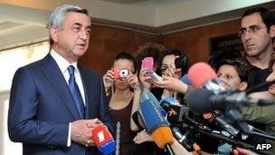 Armenian president Serge Sarkisian speaks with journalists at a polling station in Yerevan