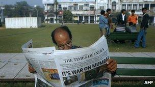 An Indian man reads a newspaper in Delhi on 27 November 2008