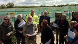 Members of the planning committee meet with the stadium site in the background