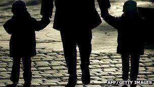 Parent walking with two children