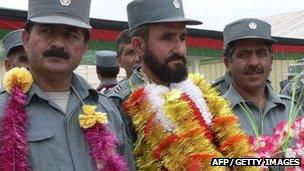 Afghan National Police personnel wear garlands during their graduation ceremony in Jalalabad, April 2012