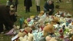 People laying flowers for baby Peter