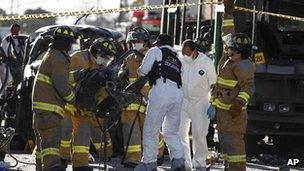 Firefighters remove the wreckage of a car