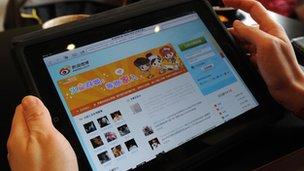 A user looking at the Weibo website on a tablet PC