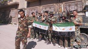 Syrian soldiers who defected to join the Free Syrian Army are seen in front of their armoured military vehicle at Khalidieh in Homs