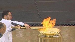 Greek weightlifter Pyrros Dimas and Chinese gymnast Li Ning (right) light the cauldron in the centre of the Panathenaic Stadium in Athens, Greece, 17 May 2012