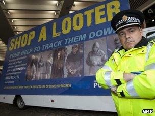 Officer with Greater Manchester Police's "Shop a Looter" billboard