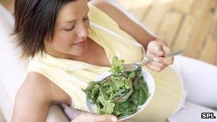 Pregnant woman eating salad