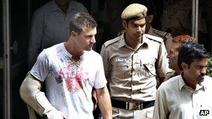 Australian batsman Luke Pomersbach is escorted by Indian policemen to be produced at a court in New Delhi, India, Friday, May 18, 2012.