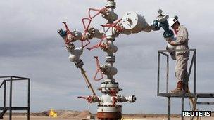 A worker measures the pressure and temperature of an oil and gas production tree October 14 2011