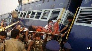 Rescuers evacuate an injured woman from the site of a train accident at a station near Penukonda, Andhra Pradesh