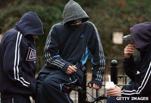 Young people with hooded tops drinking in public place