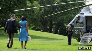 The Obamas walk across the South Lawn of White House to waiting helicopter