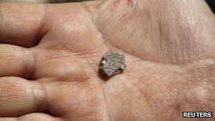 Ancient seal on archaeologist's hand