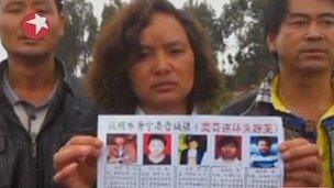 China killings - woman holds up poster