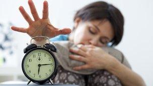 Tired woman switching off alarm