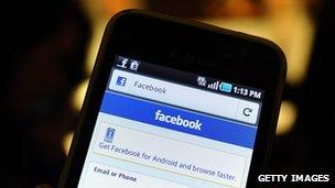 A smartphone displays a Facebook app