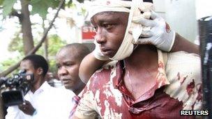 A man injured during an explosion is assisted from the scene in Kenya's capital Nairobi, May 28, 2012.