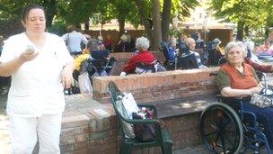 Old people's home residents sit in the home's front garden