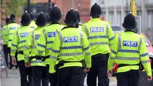 A group of police officers walking down a road