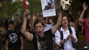 Demonstrators shout slogans against the government during a protest in front a Bankia bank branch in Barcelona, Spain, Saturday June 2, 2012