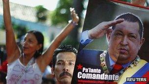 A supporter of Venezuelan President Hugo Chavez holds a poster of Chavez during an United Socialist Party campaign rally in Caracas, 1 June 2012