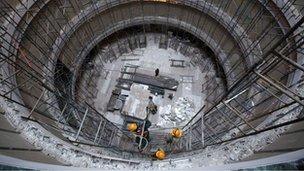 Construction workers erect scaffolding at the site of a commercial building in Mumbai 2 May, 2012