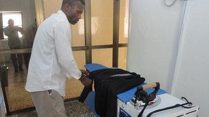 An employee of the Somalia Premium Laundry checks a rail of clothes.