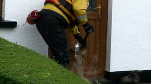 The door of Mike Barber's home is broken to let water out