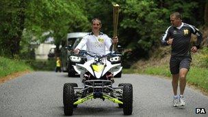 John Mitchell riding out of Lewis Castle College with the flame