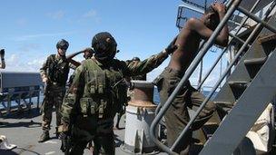 French soldiers escort suspected Somali pirates on board a warship in 2009 as part of an EU operation