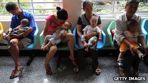 People holding babies who drank tainted milk powders queue to receive examination in a Hospital in Wuhan, China, 17 Sept 2008