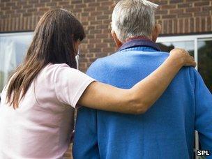 Woman helping an elderly man to his door