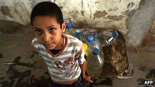 Yemeni boy waits for his turn to fill water bottles