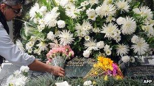 A tourist leaves flowers on Pablo Escobar's grave in Medellin - file photo