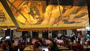 Tourists and locals sit in restaurants on Monastiraki Square in Athens