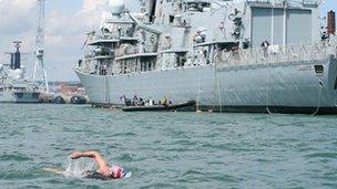 Miss Wardley swimming past a ship