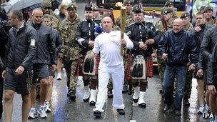 Dave Watson carries the Olympic Flame on the Torch Relay leg through Lancaster