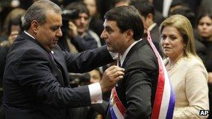 Congressional President Jorge Oviedo Matto, left, places the presidential sash on Paraguay"s former Vice President Federico Franco